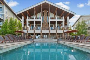 a swimming pool with chairs and a building at Seasons 331 - Penthouse in Sandpoint