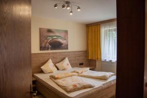 a bedroom with a bed with pillows on it at Haus Madeleine in Neustift im Stubaital