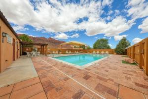 a pool with tables and chairs in a yard at Rim Village D4 in Moab
