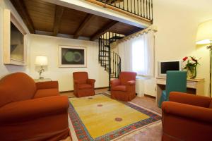 a living room with chairs and a table and a television at Sovana Hotel & Resort in Sovana