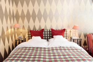 a bedroom with a bed with red and green pillows at Romantik Hotel Jagdhaus Waldfrieden in Bilsen