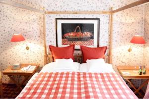 a bedroom with a bed and two tables with lamps at Romantik Hotel Jagdhaus Waldfrieden in Bilsen