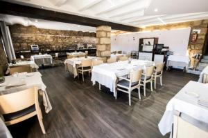 ein Esszimmer mit weißen Tischen und Stühlen in der Unterkunft Hotel Restaurante Masía la Torre in Mora de Rubielos