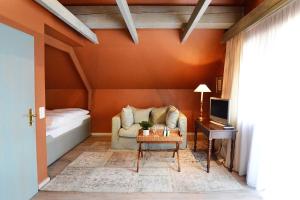 a living room with a couch and a bed at Romantik Hotel Jagdhaus Waldfrieden in Bilsen