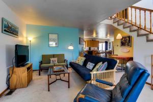 a living room with a blue couch and a tv at Nye Beach Bungalow in Newport