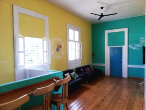 a living room with green and yellow walls and a couch at Park Hostel in Port-au-Prince