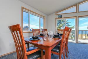 a dining room with a table and chairs and windows at Anchor Away at Lincoln City in Lincoln City