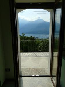 uma porta para uma varanda com vista para o oceano em Apartment Rosa Dei Venti em Gravedona