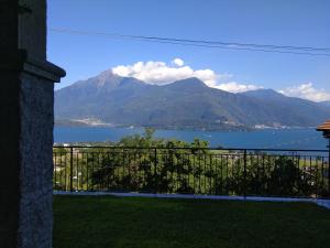 uma varanda com vista para um lago e para as montanhas em Apartment Rosa Dei Venti em Gravedona