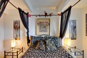 a bedroom with a canopy bed with two lamps at Sebastian's Crib Condo in Lincoln City