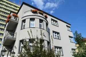 een wit gebouw met bloempotten op de ramen bij Hostel Gwarek in Katowice