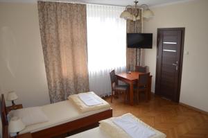 Cette chambre comprend un lit, un bureau et une fenêtre. dans l'établissement Hostel Gwarek, à Katowice