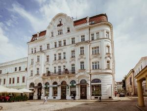a large white building with a woman walking in front of it at Deer Apart in Cieszyn