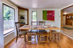 - une salle à manger avec une table et des chaises en bois dans l'établissement Ridge Path Cottage, à Gearhart