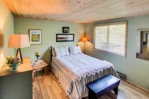 Un dormitorio con una cama y un escritorio y una ventana. en The Beach House on Lopez Island, en Lopez 16 fotos más