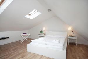 a white bedroom with a white bed and a desk at Day Dream Laugavegur Downtown Apartments in Reykjavík