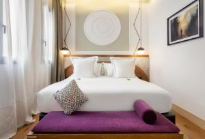 1 dormitorio con 1 cama blanca grande con alfombra morada en One Shot Fortuny 07, en Madrid