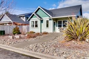 a green and white house with a gravel driveway at Bonnie Dune in Manzanita