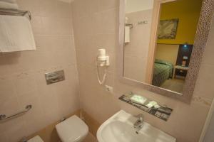 Un baño con lavabo, inodoro y espejo. en Alex Place, en Roma