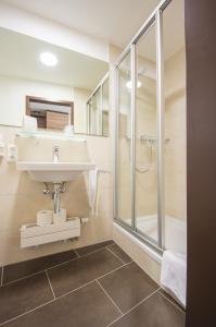 ein Bad mit einem Waschbecken und einer Dusche in der Unterkunft Ammerseehäuser in Dießen am Ammersee