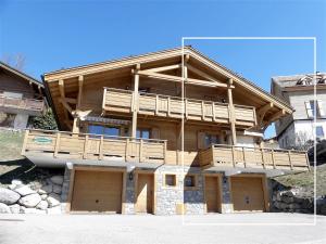 ein großes Holzhaus mit Balkon in der Unterkunft Aulp de Suz 2 - Chalet avec vue in La Clusaz