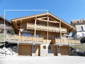 una grande casa in legno con balcone di L'Aulp De Suz 1 - Demi chalet a La Clusaz