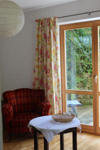 a living room with a chair and a table and a window at Haus Hilgenfeld in Bad Sooden-Allendorf