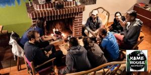 grupa ludzi siedzących przed kominkiem w obiekcie Kame House hostel w mieście Huaraz