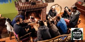 a group of people sitting in front of a fireplace at Kame House hostel in Huaraz