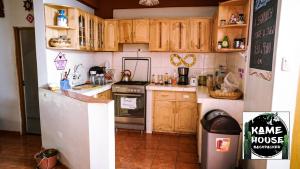 a kitchen with wooden cabinets and a refrigerator at Kame House hostel in Huaraz