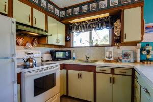 a kitchen with a white stove top oven next to a window at Darrs Beach Cottage in Neskowin