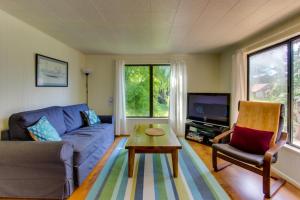 ein Wohnzimmer mit einem blauen Sofa und einem Tisch in der Unterkunft Ridge Path Cottage in Gearhart