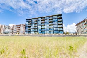 a tall building with a field in front of it at Sand & Sea: The Promenade (100) in Seaside