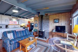 - un salon avec un canapé bleu et une table dans l'établissement Sea Mist Cottage, à Searose Beach