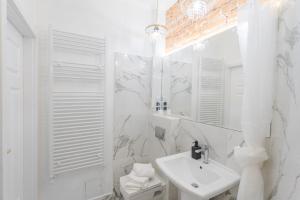 a white bathroom with a sink and a mirror at Crystal Apartament in Lublin