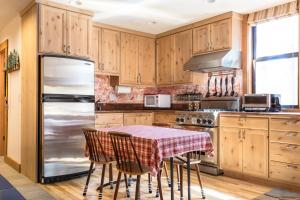 eine Küche mit einem Tisch und einem Kühlschrank in der Unterkunft Aspen Grove Studio at Northstar in Truckee