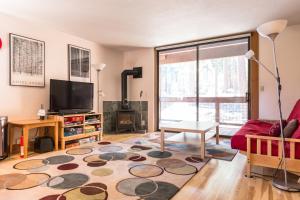 a living room with a couch and a tv at Aspen Grove Studio at Northstar in Truckee