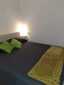a bed with two lime green pillows on it at Il Cortile in Clusane sul Lago