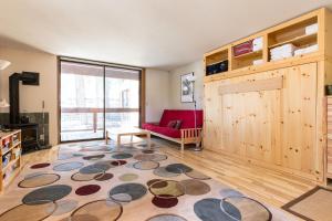 a living room with a red couch and a rug at Aspen Grove Studio at Northstar in Truckee