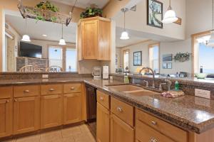 a large kitchen with wooden cabinets and a sink at Sunset Beach House in Gold Beach