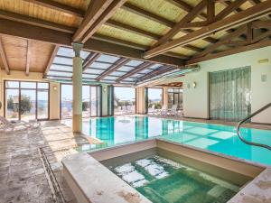 an indoor swimming pool with an open ceiling at Agriturismo Baccoleno in Asciano