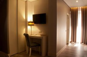 um quarto com uma secretária com um candeeiro e uma cadeira em Aqua Ria Boutique Hotel em Faro