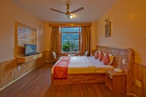 a bedroom with a large bed and a window at The Holiday Resorts and Cottages in Manāli