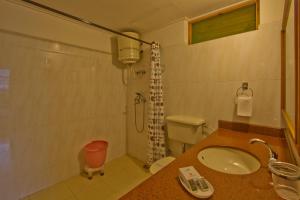 a bathroom with a sink and a shower at The Holiday Resorts and Cottages in Manāli