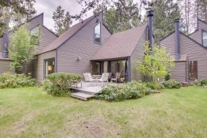a gray house with a patio and chairs in the yard at Mt View Condo 22 | Discover Sunriver in Sunriver