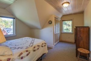 a bedroom with a bed and two windows at North End Nook in North Hero