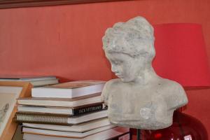 a bust of a girl next to a stack of books at Chez Jeanne et Vittorio in Lambersart