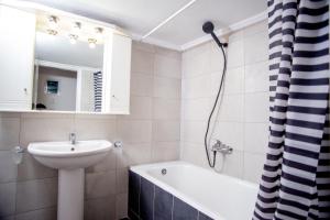 塞薩羅尼基的住宿－Thessaloniki Center Apartment On The Sea，浴室配有盥洗盆、卫生间和浴缸。