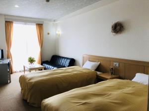 小谷村贝尔猪俣艺典旅馆的有两张床和一张沙发的酒店房间