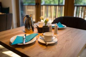 uma mesa de madeira com pratos e um bule de chá em Rieslingquartier - Mosel Wein Hotel em Kröv